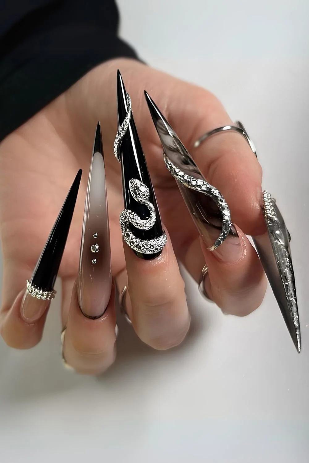 Extra lange Naegel in Schwarz und Silber mit aufwendigem Design