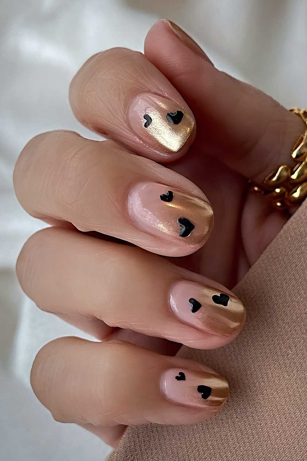 Goldene Ombre Naegel mit schwarzen Herzen