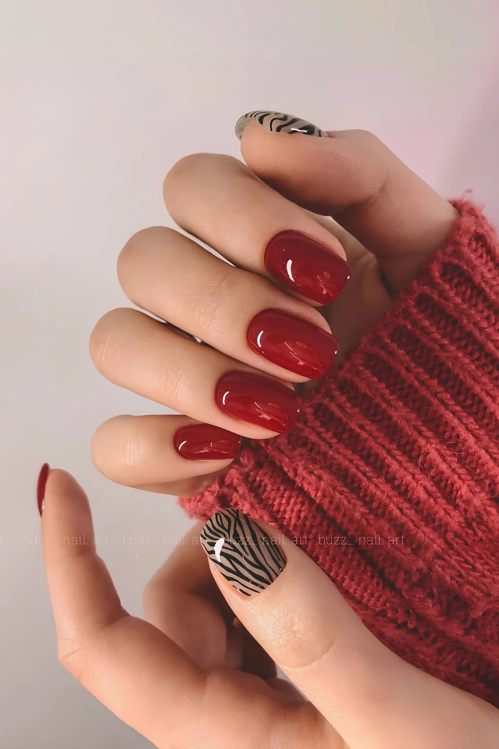 Kirschrote Nägel mit Zebra-Print-Akzent