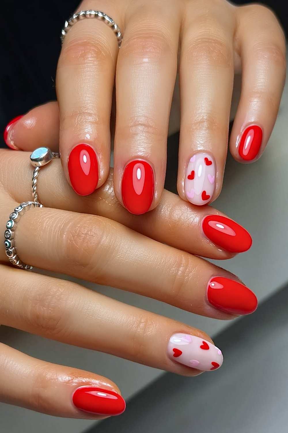 Klassische rote Manikuere mit rosa und roten Herzen