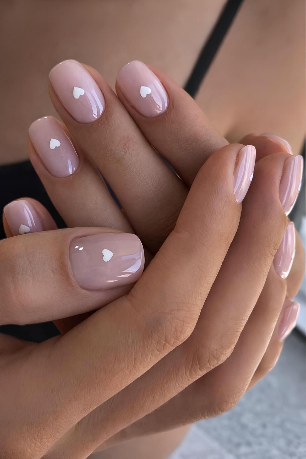 Kurze transparente Naegel mit weissen Herzen