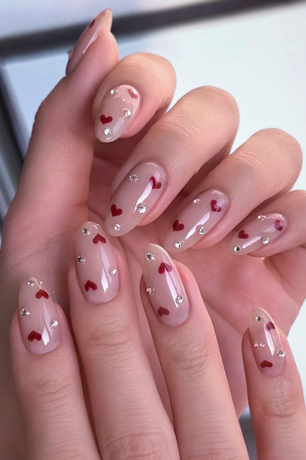 Milchige Naegel mit roten Herzen und Strass