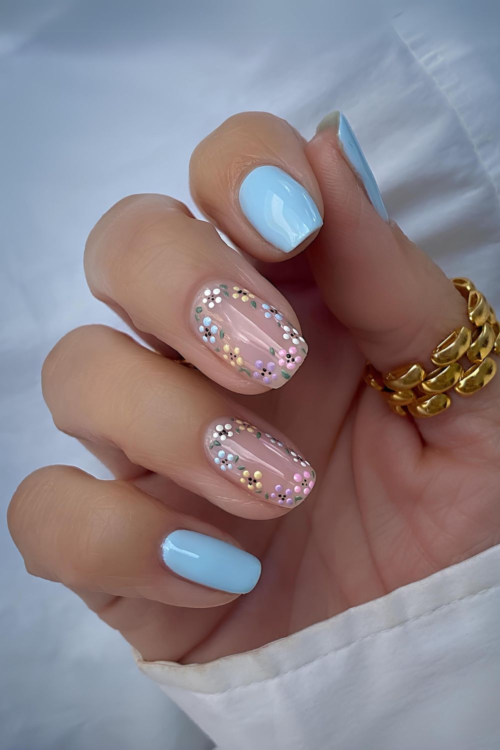 Babyblaue Mani mit bunten Blumen-Details