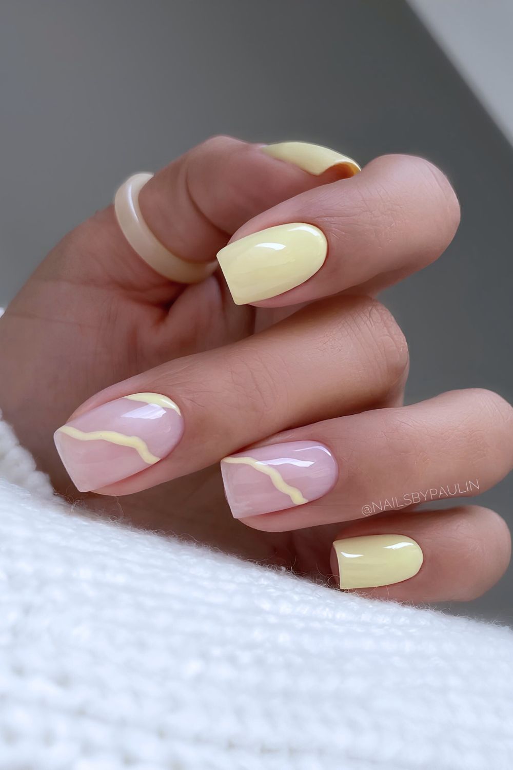 Buttergelbe Nägel mit filigraner Linienkunst