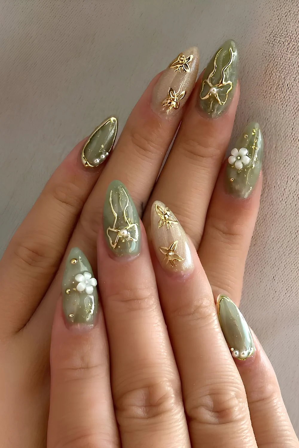 Grün-goldene Nägel mit 3D-Blumen und Schleifen