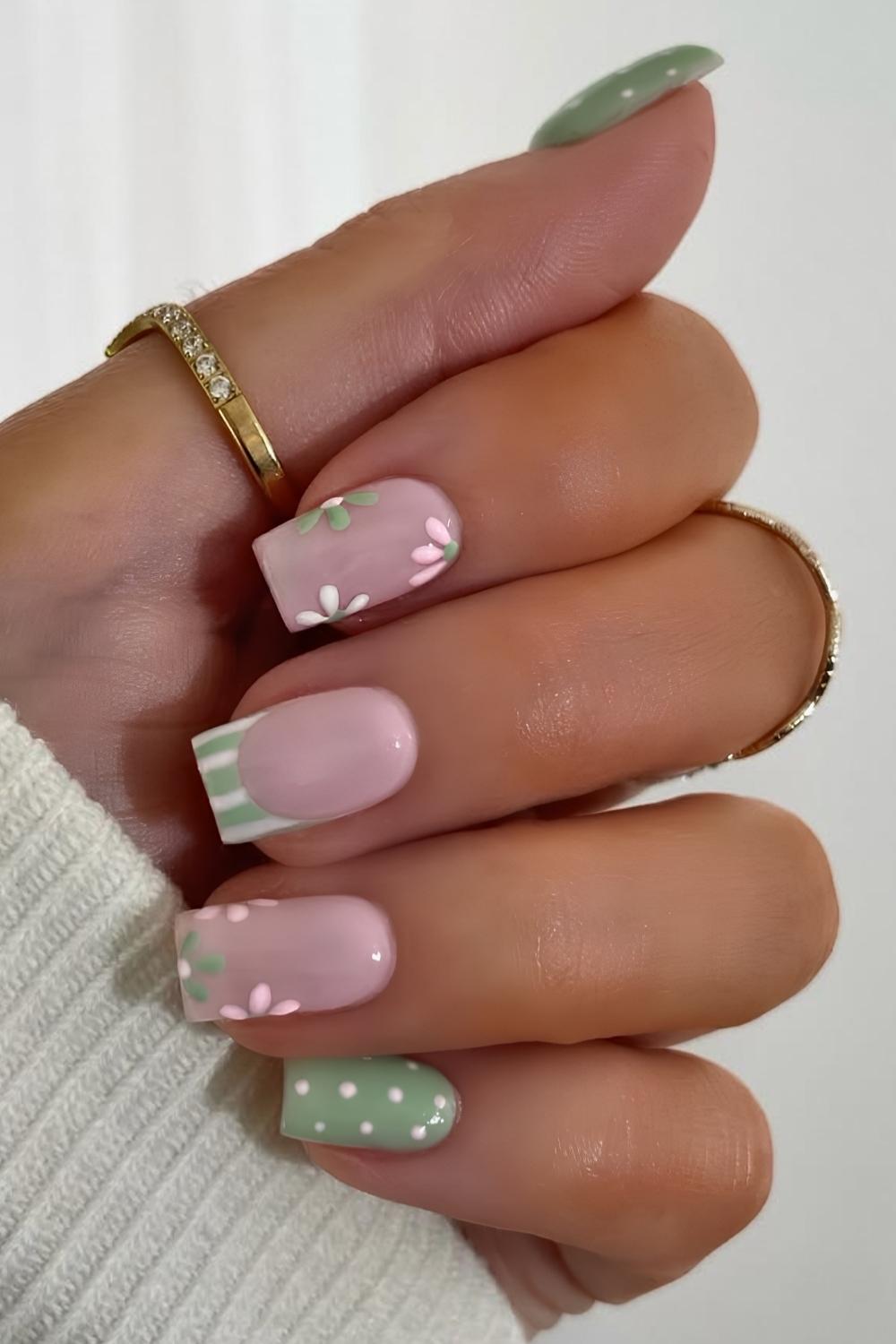 Gruene und pinke Manikuere mit Blumen und Streifen