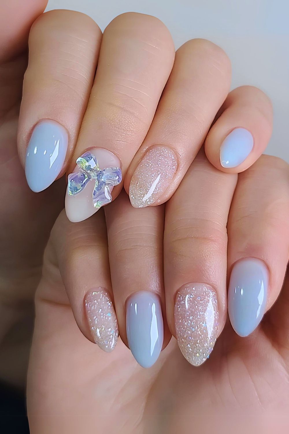 Hellblaue Mani mit Schleifen und Glitzer