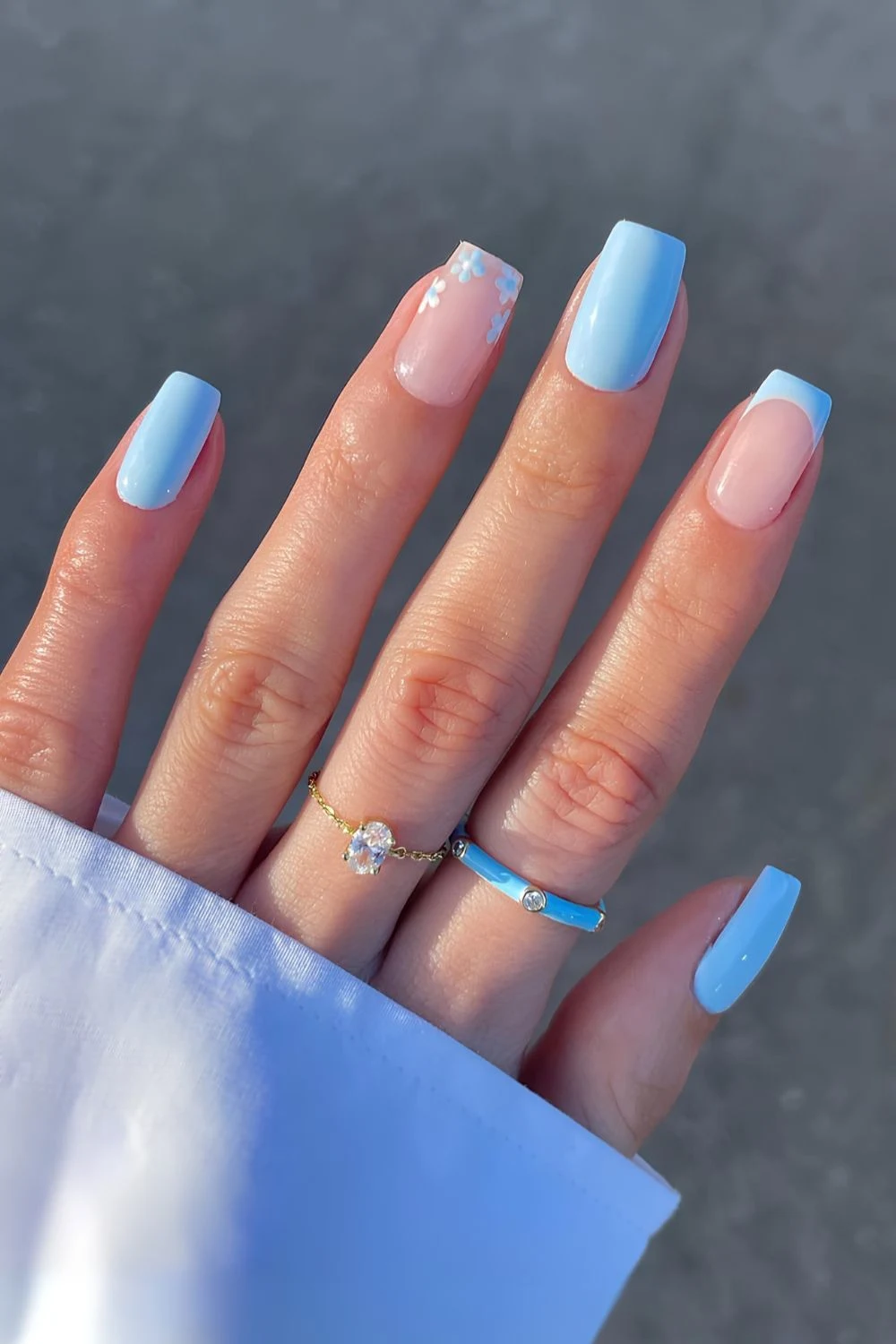 Hellblaue Nägel mit feinem Blumenmuster