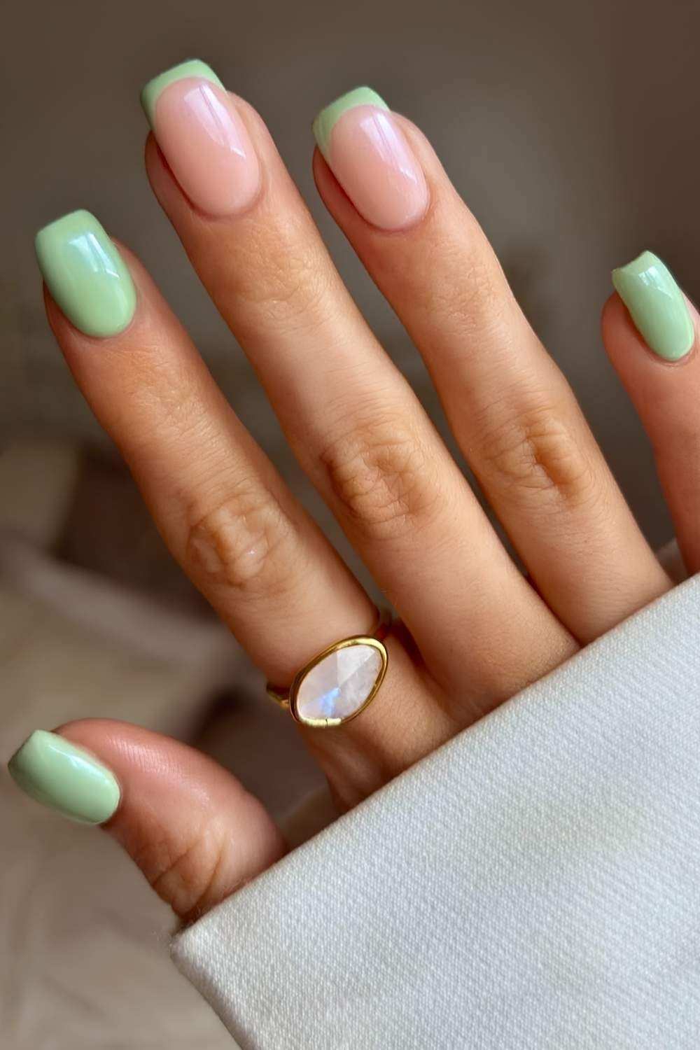 Hellgruene Naegel mit French Tips als Akzent