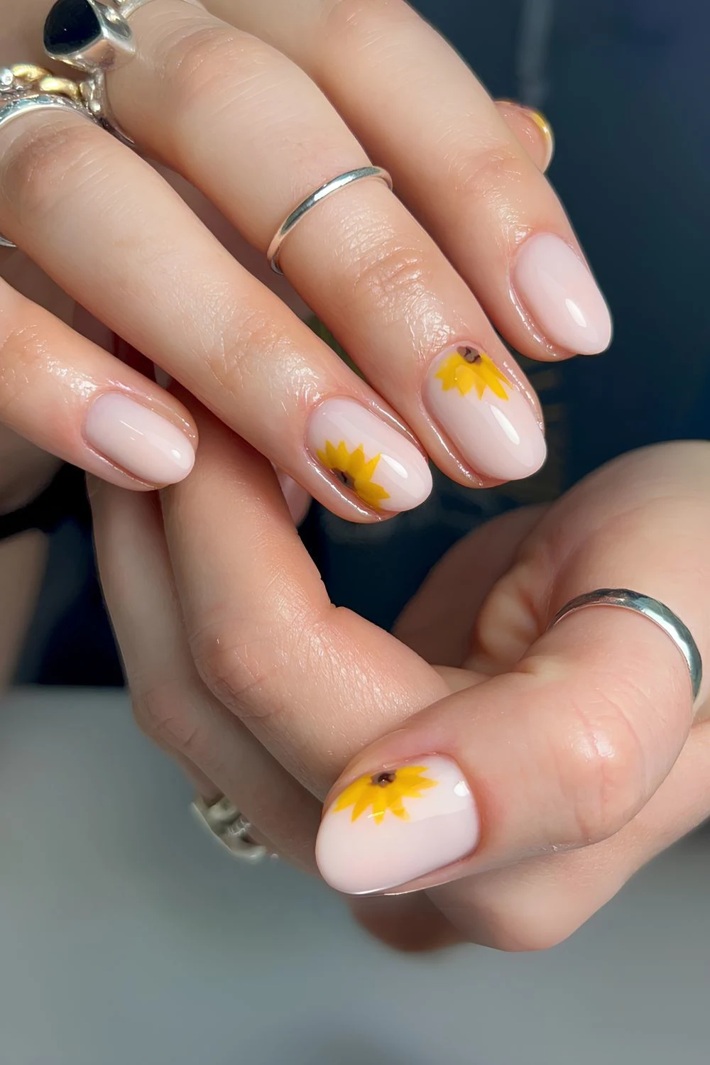 Milchige Nägel mit Sonnenblumen-Artwork