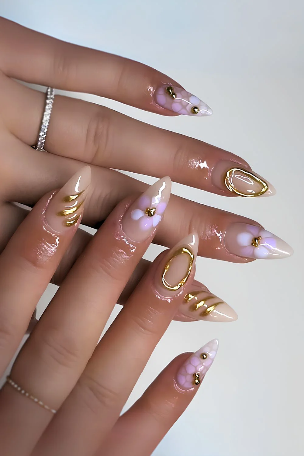 Milky Nails mit lila Blüten & Gold-Chrome