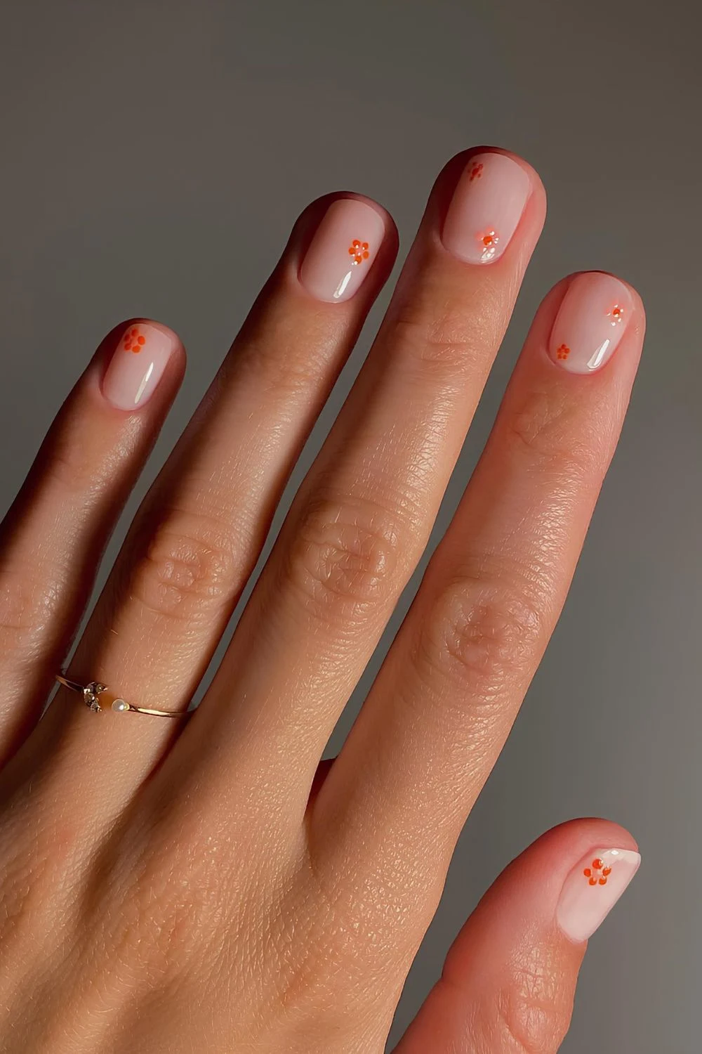 Neutrale Nägel mit orangenen Blumen-Details