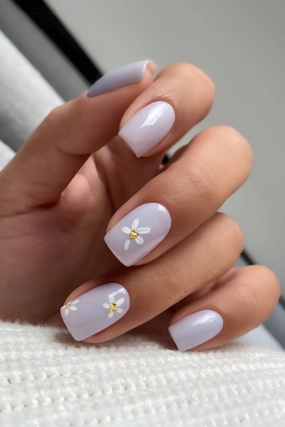 Periwinkle-Mani mit Gänseblümchen-Design
