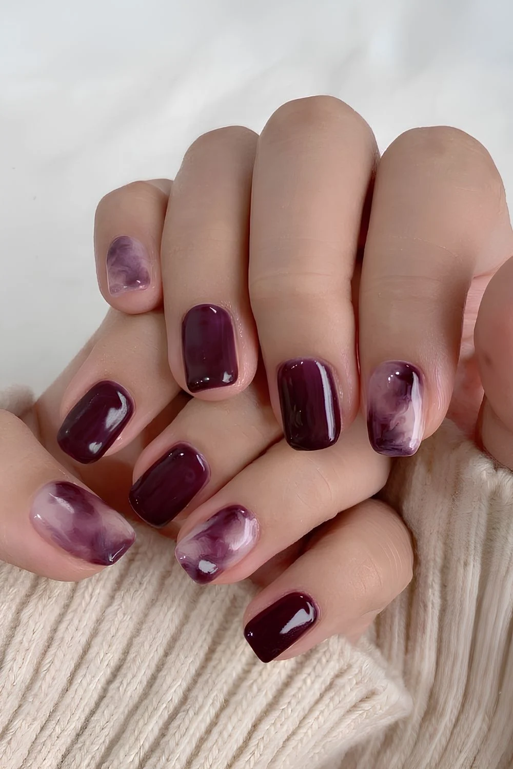 Pflaumenfarbene Nägel mit Marmor-Wirbeln