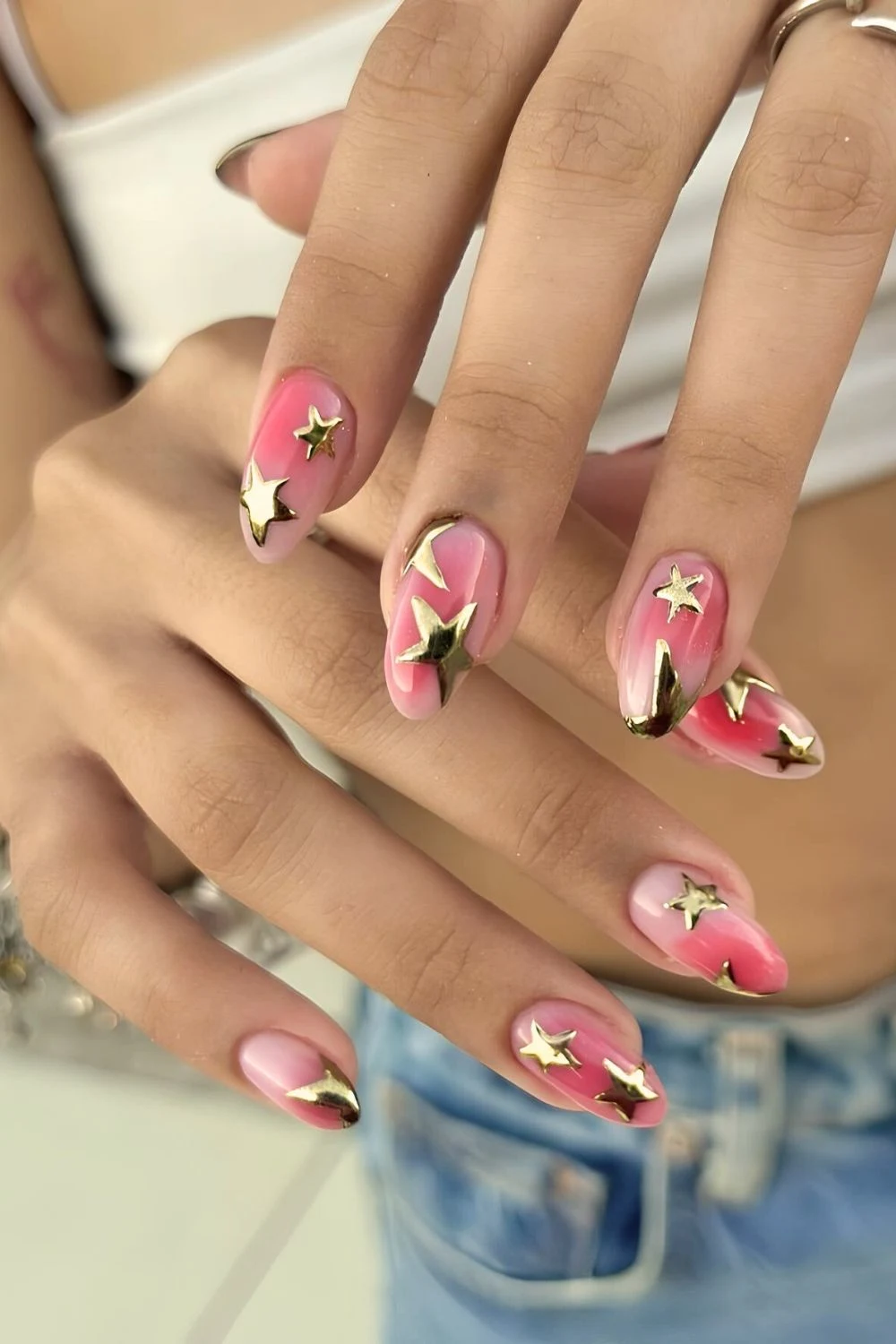 Rosa-Aura-Nägel mit goldenen Chrome-Sternen