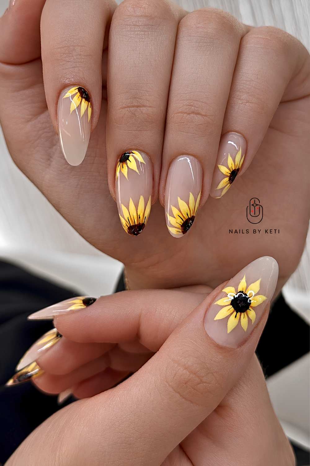 Transparente mandelfoermige Mani mit Sonnenblumen