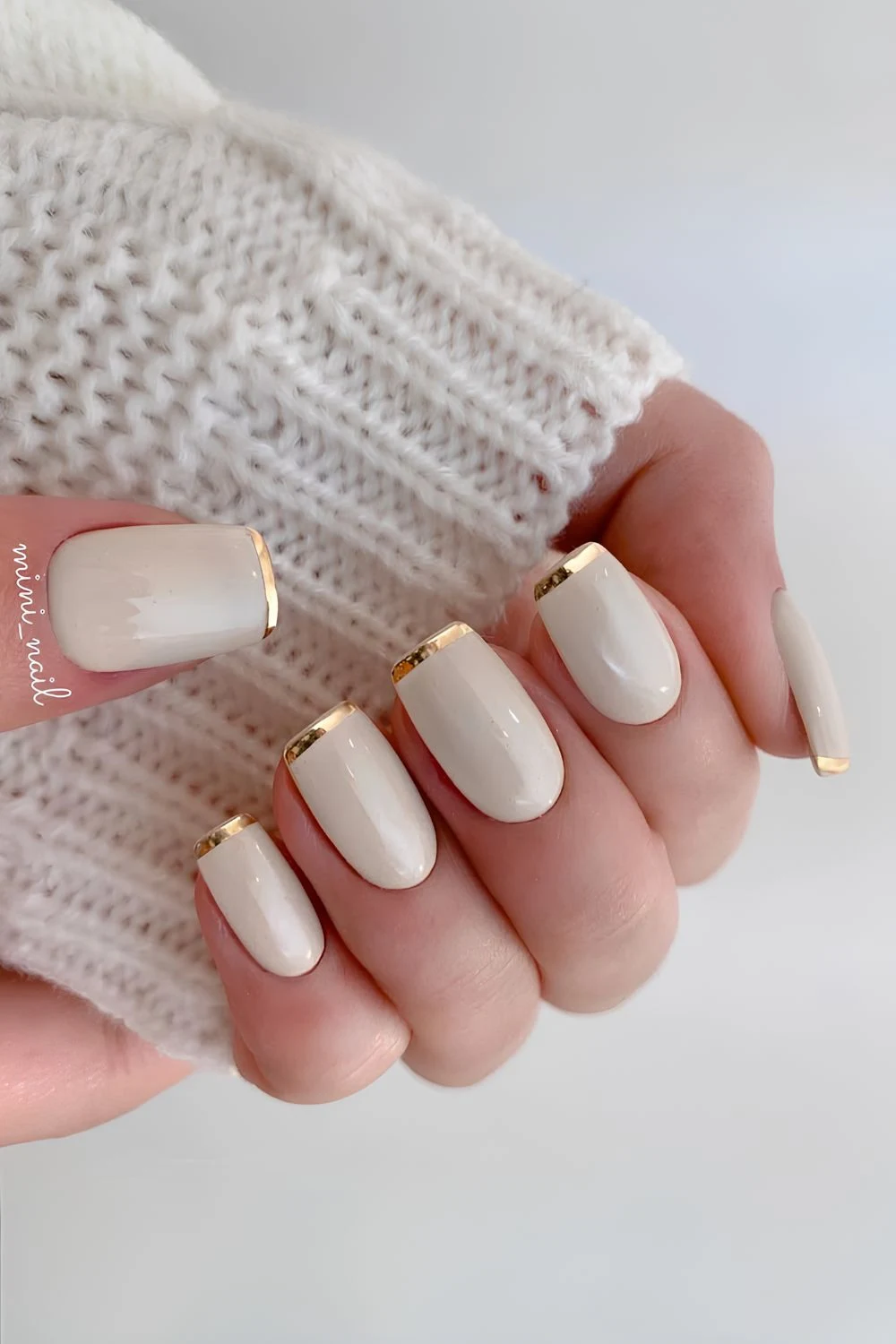 Weiße Nägel mit schmalen goldenen French Tips