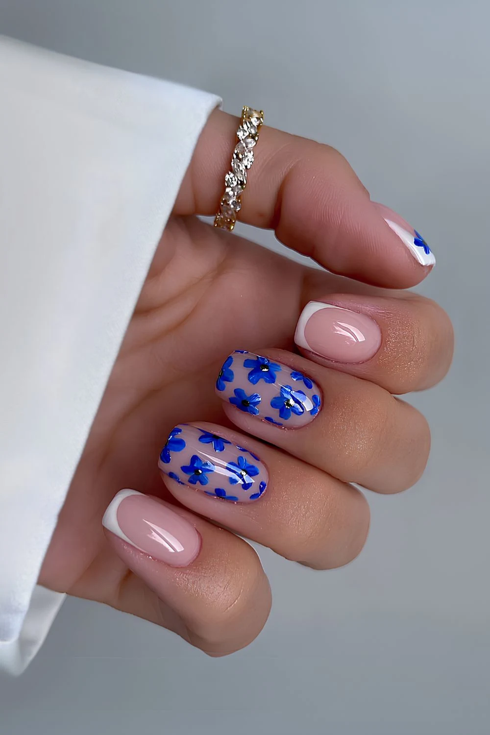 Weiße French-Mani mit blauen Blumen