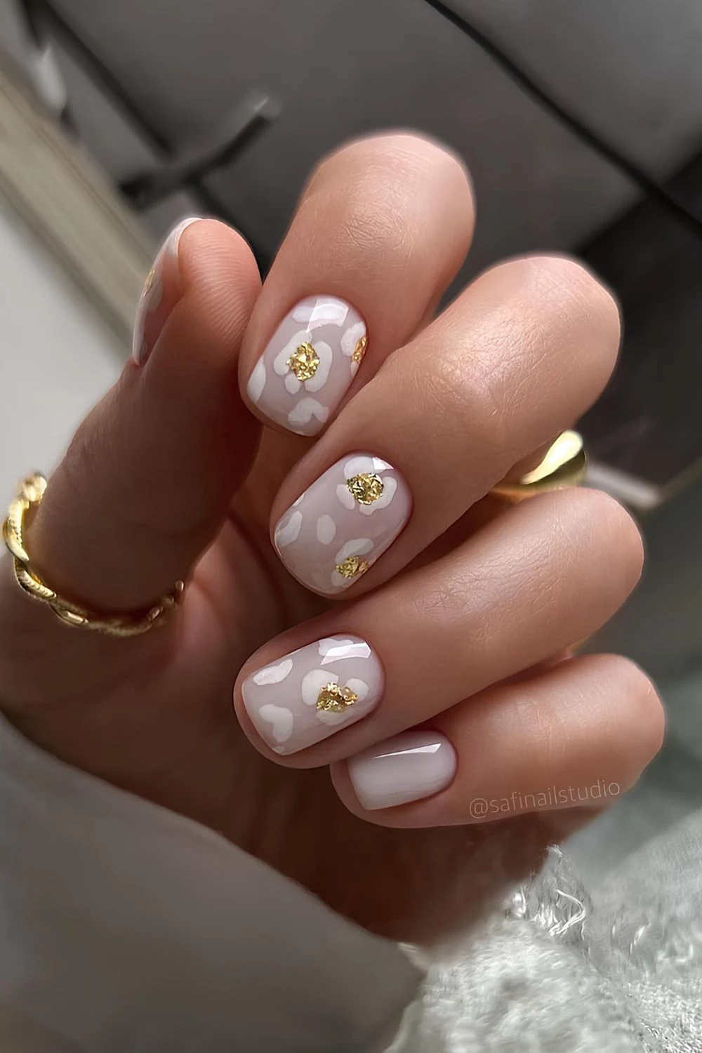 Weiße Leopard-Print Maniküre mit goldenen Akzenten