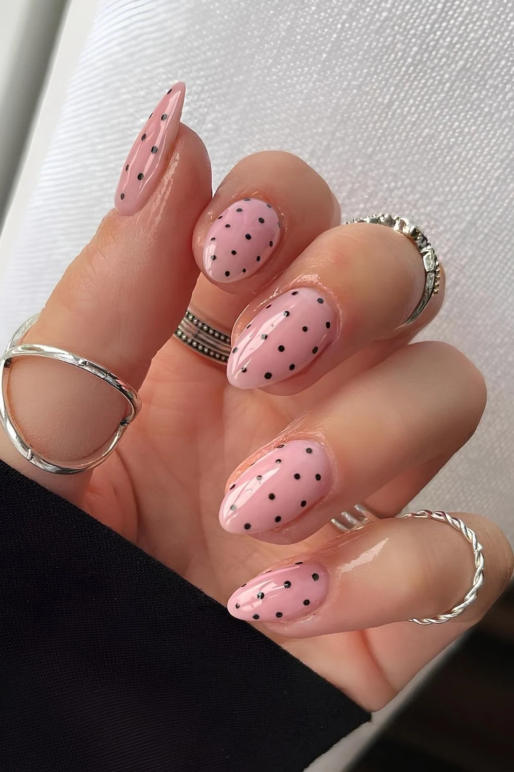 Gl&auml;nzende rosa N&auml;gel mit schwarzen Polka-Dots
