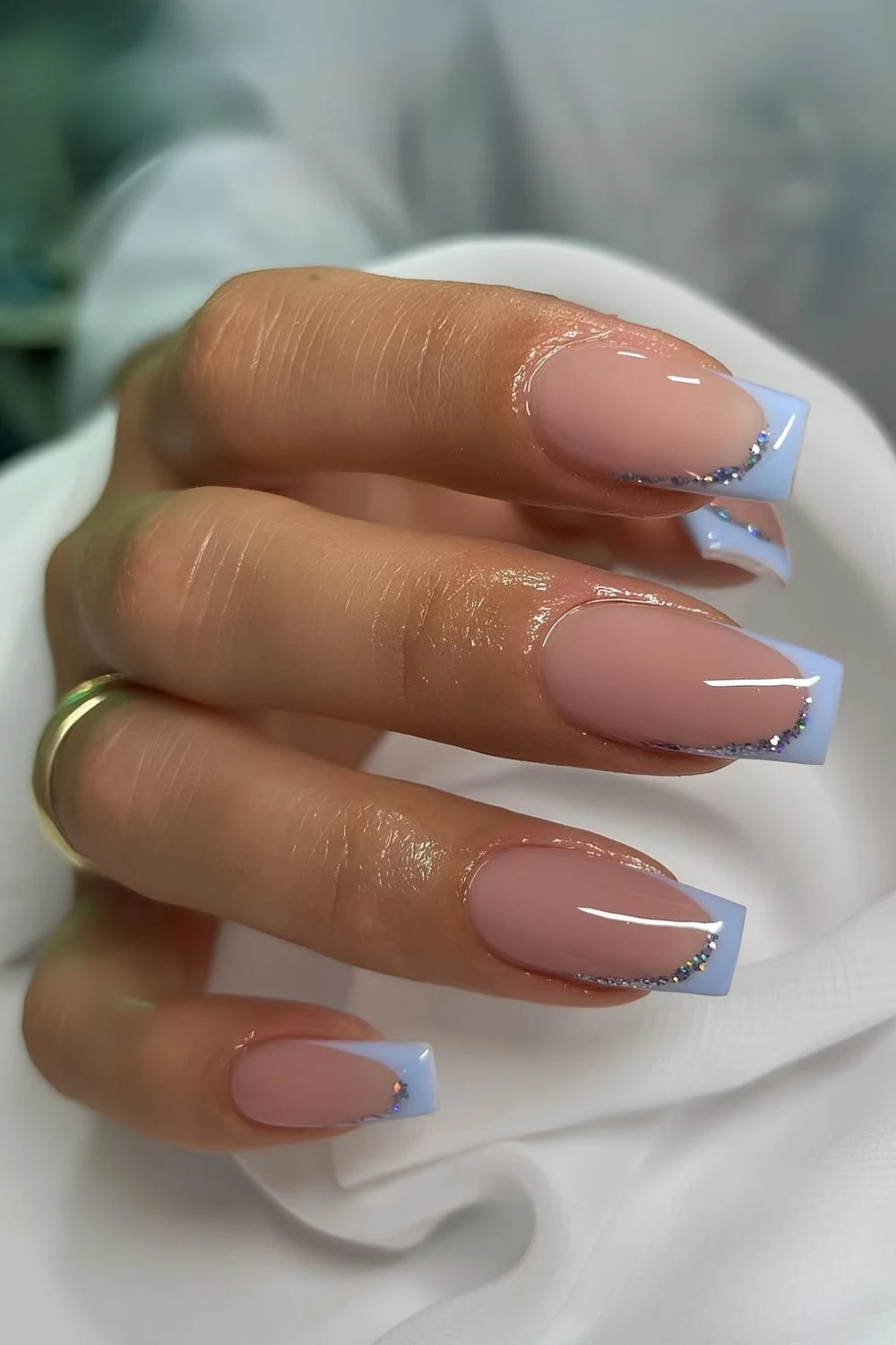 Hellblaue French-Nägel mit Glitzerakzent