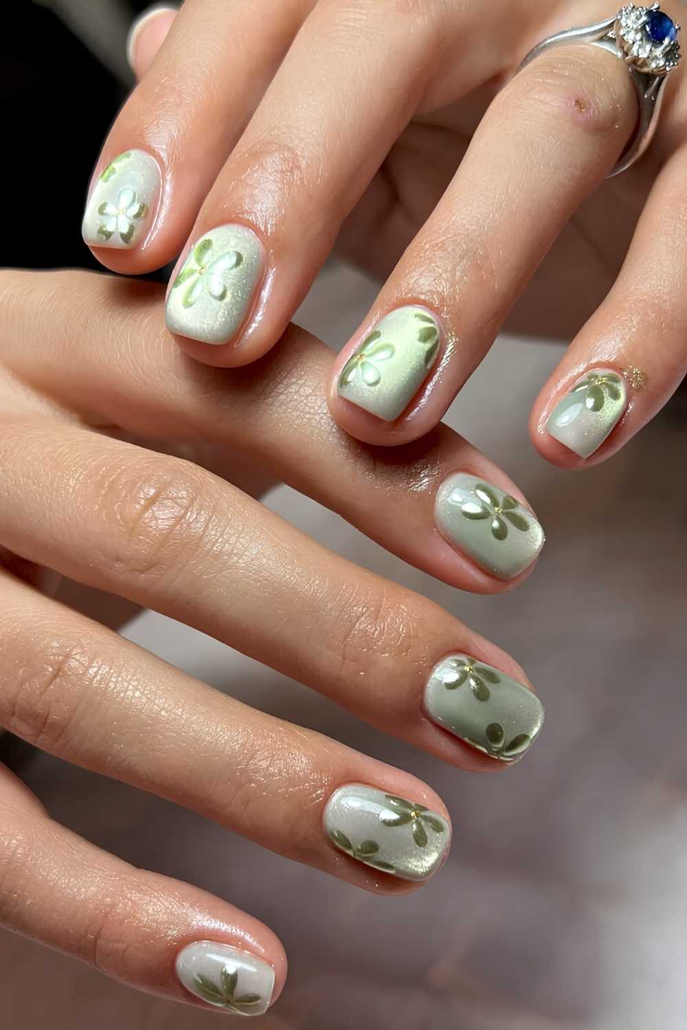 Kurze gruene Cat Eye Naegel mit Blumen