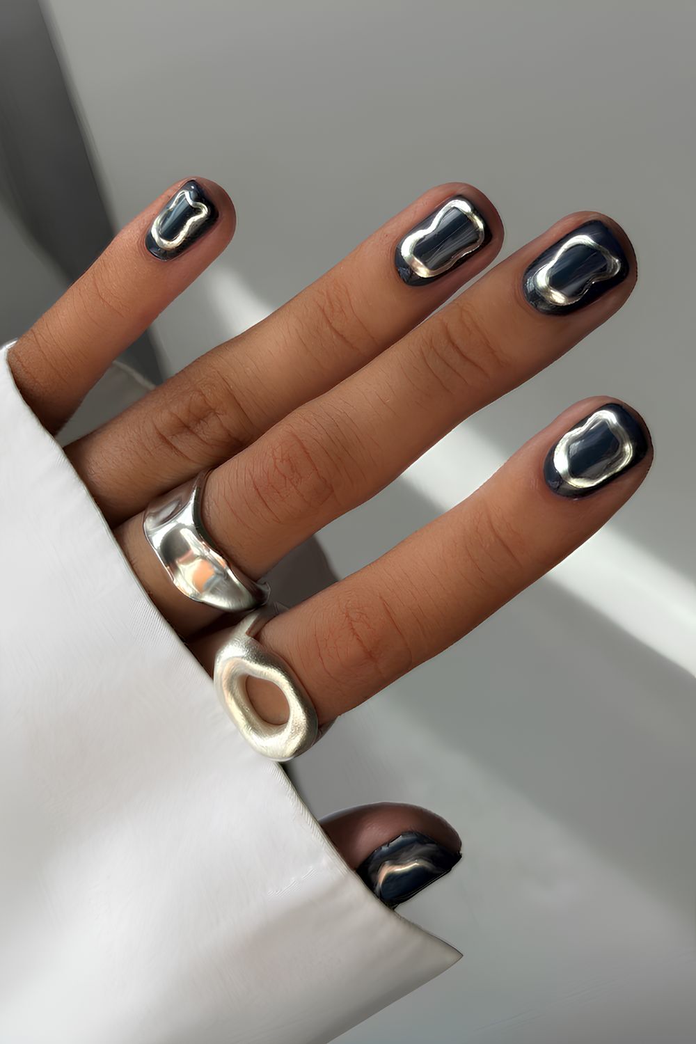 Kurze schwarze Nägel mit silbernen Chrome-Details