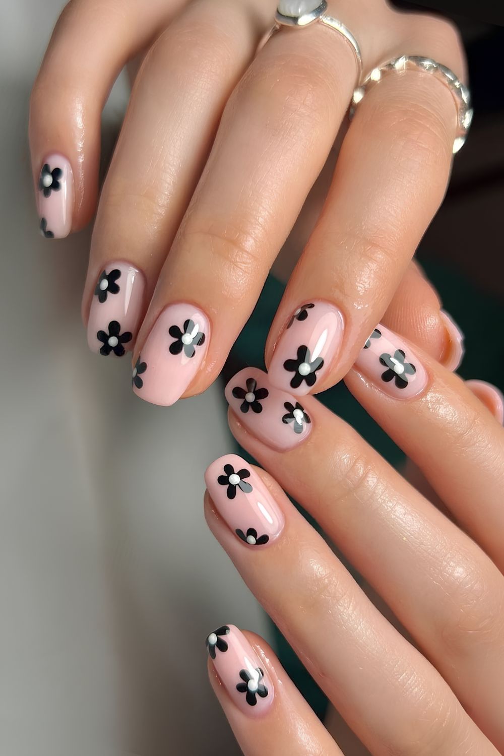 Milchig rosa Nägel mit schwarzen Blumen