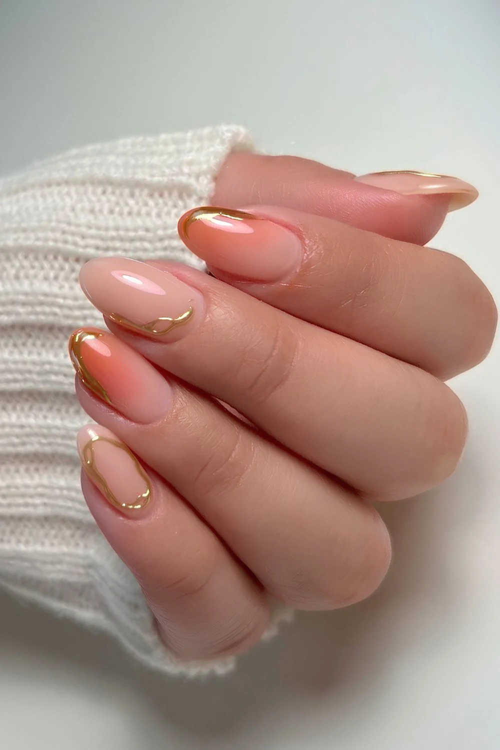 Milchige Nägel mit Gold- und Pfirsichakzenten