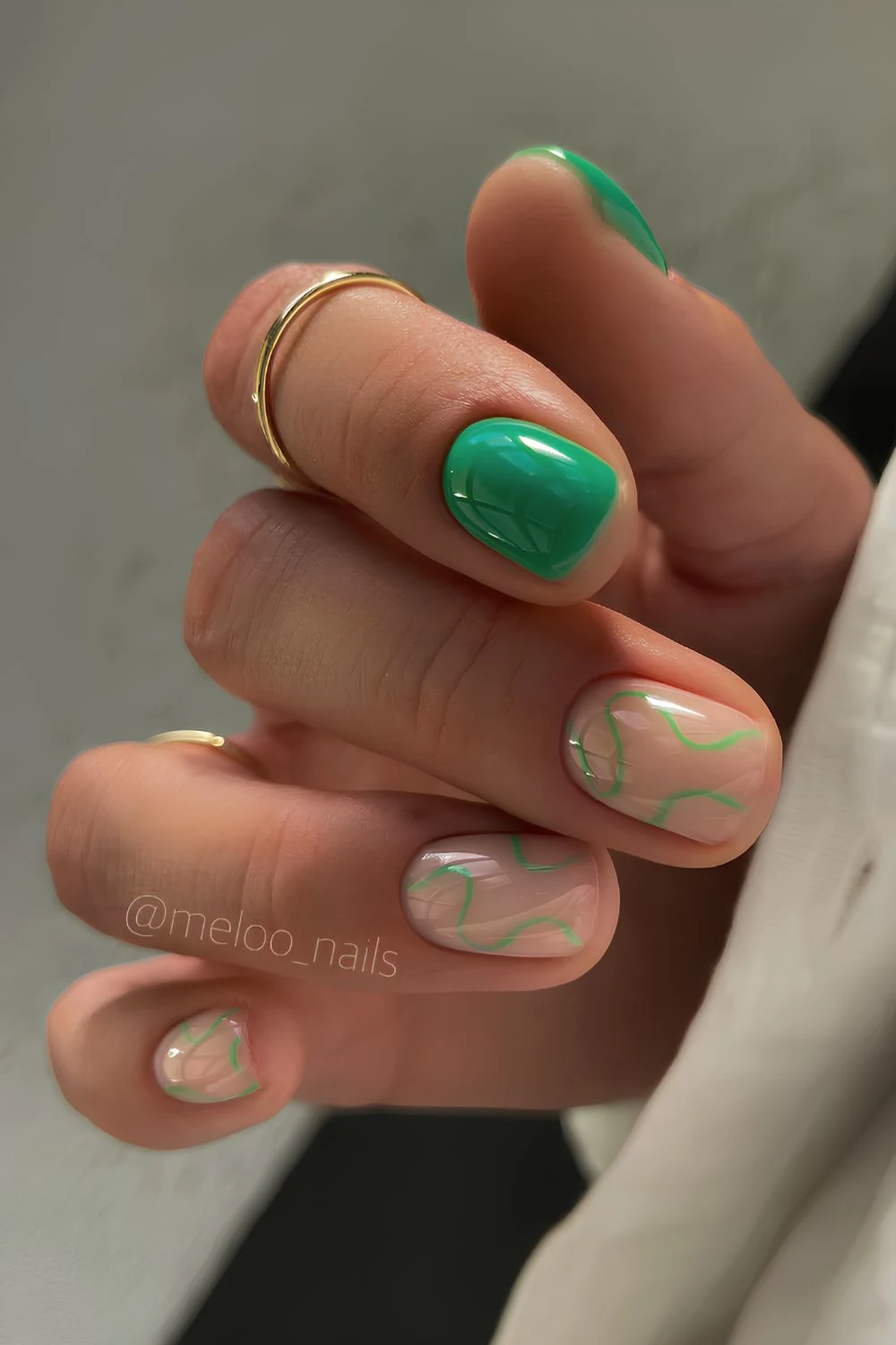 Milchige Nägel mit leuchtend grünen Swirls