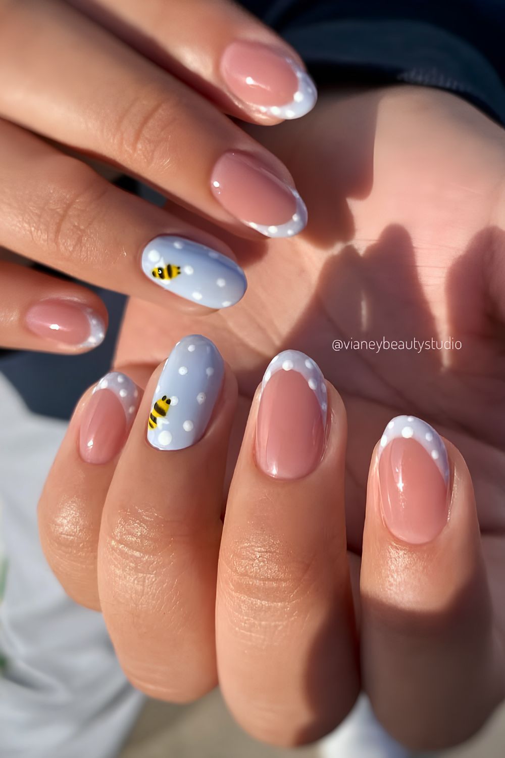Pastellblaue Naegel mit Bienen