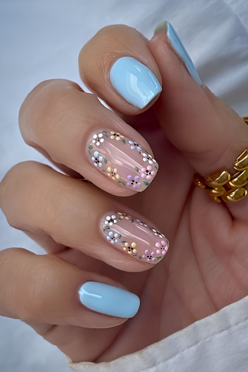 Pastellblaue Naegel mit Mini Blumen
