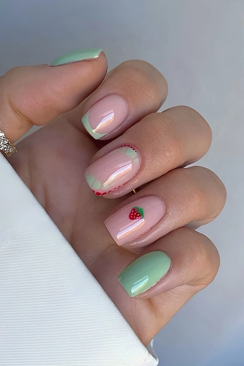 Pastellgrüne Nägel mit Erdbeer-Motiven