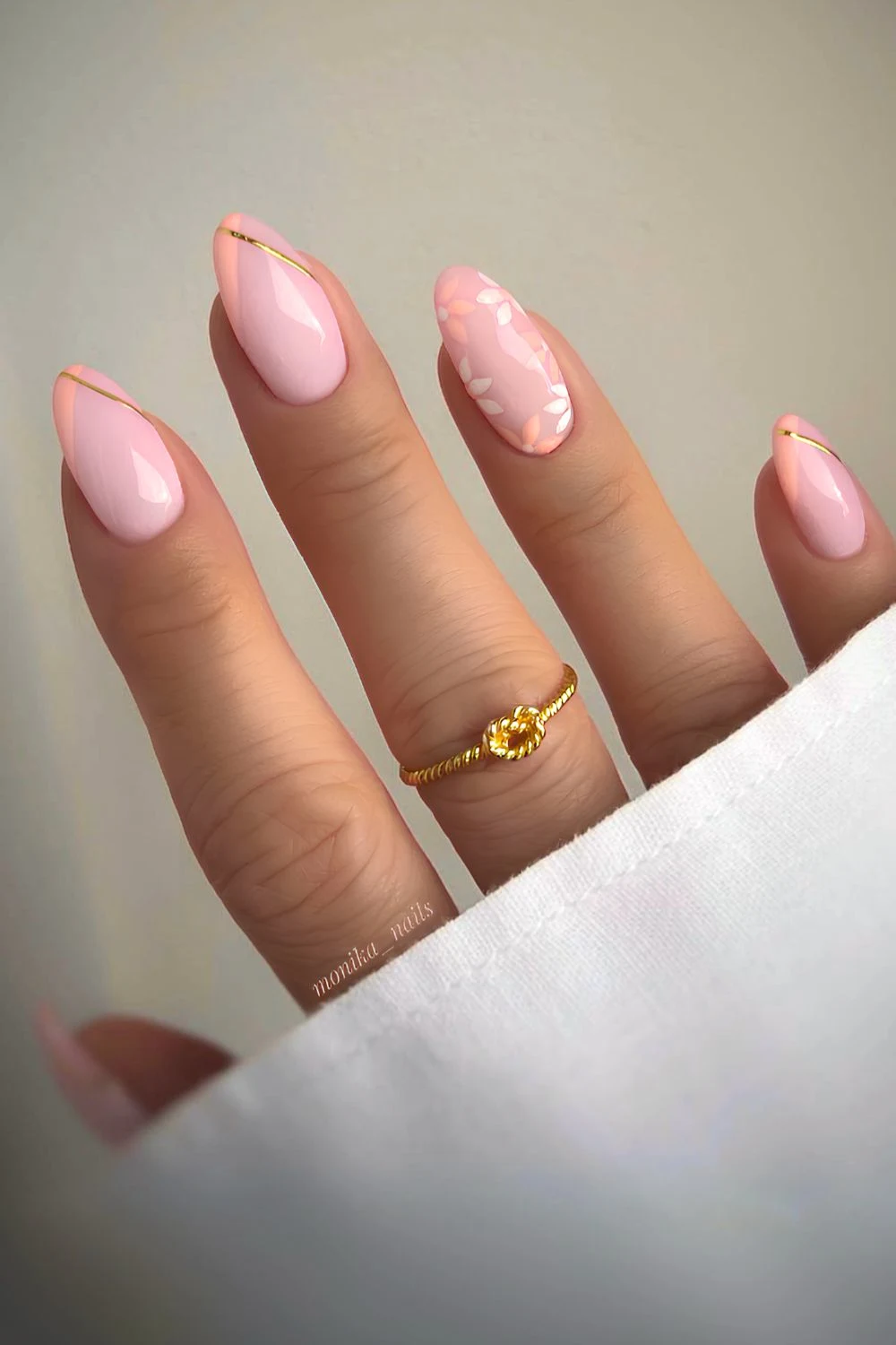 Pfirsich-French-Nägel mit Blumen- und Goldakzenten