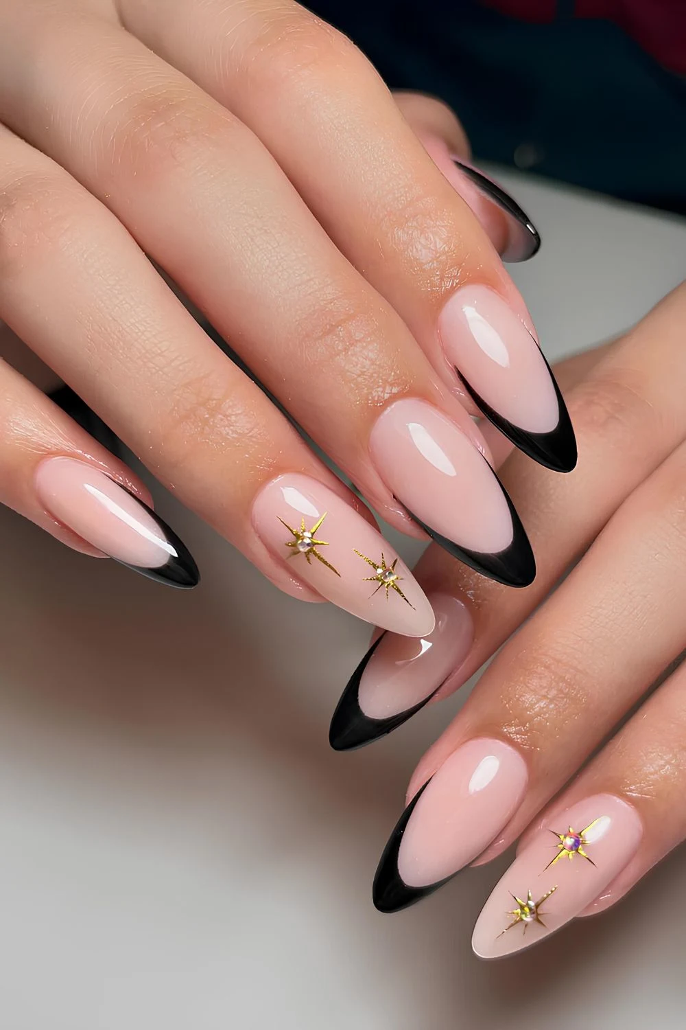 Schwarze French-Nägel mit goldenen Chrome-Sternen