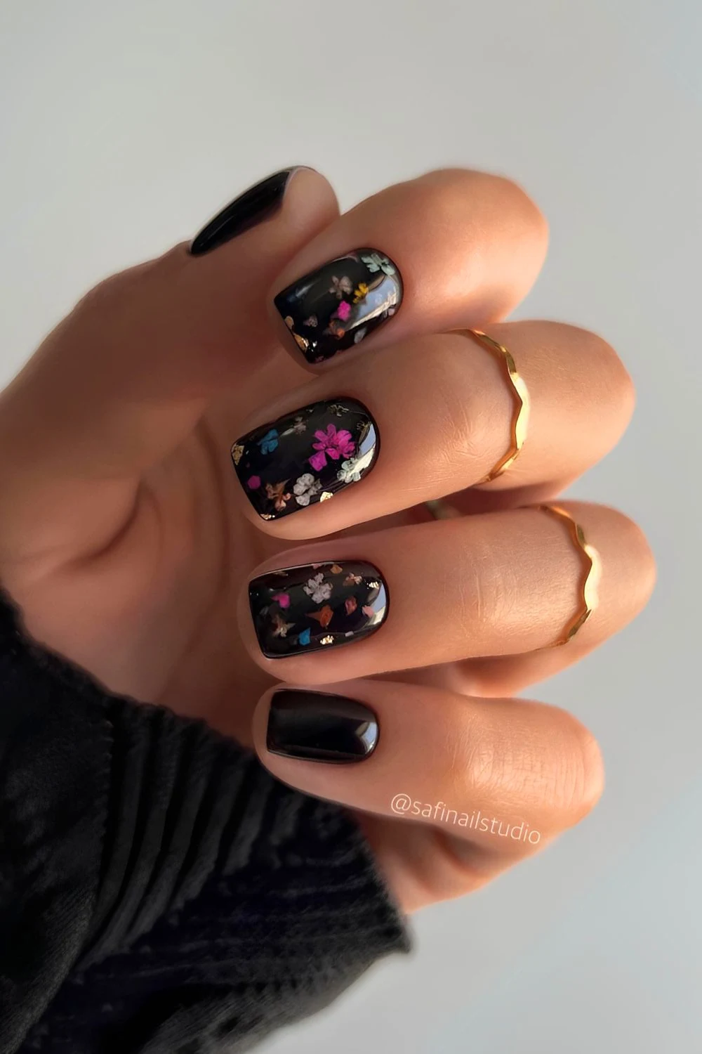 Schwarze Nägel mit kleinen bunten Blumen