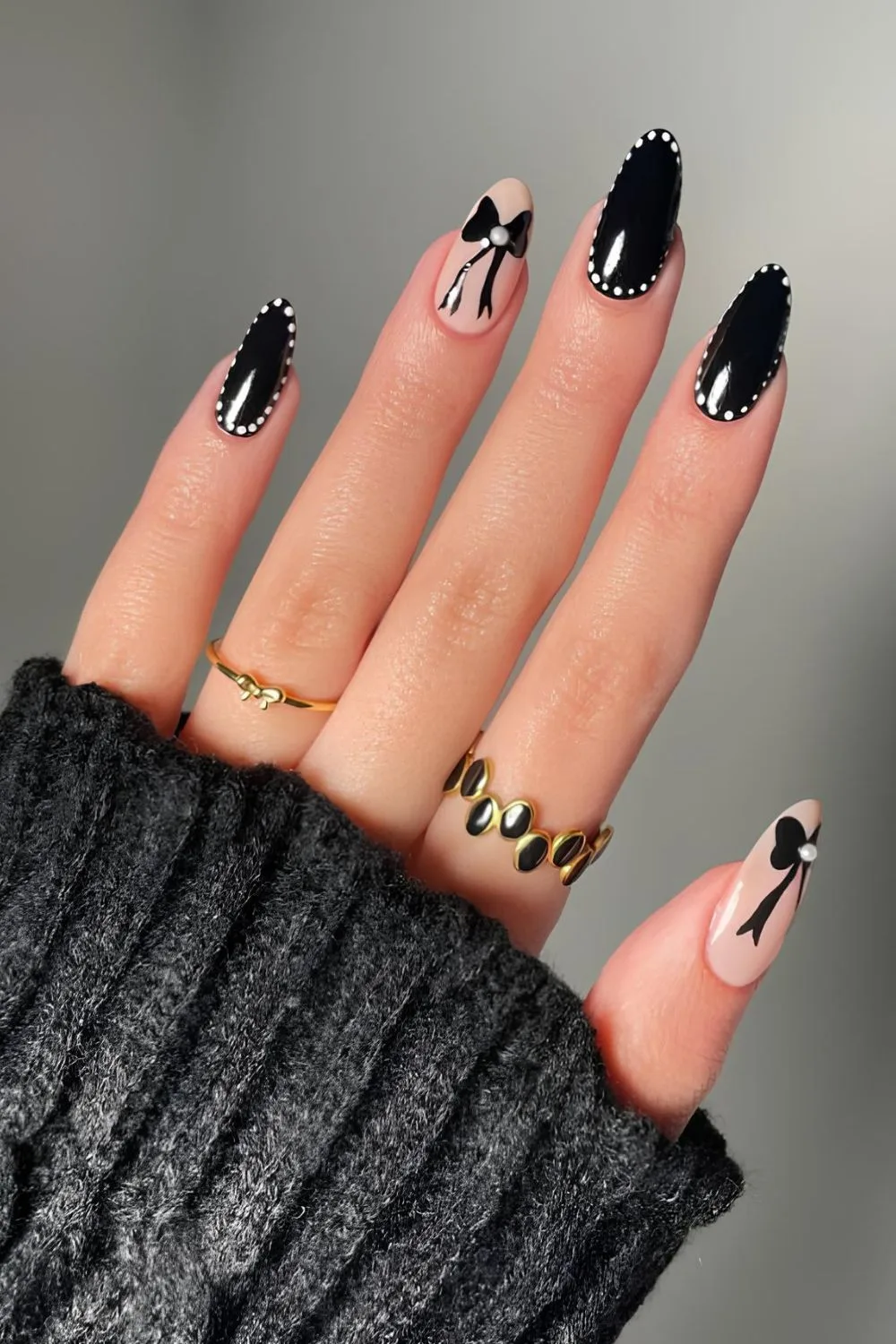Schwarze Nägel mit weißen Punktumrandungen und Schleife