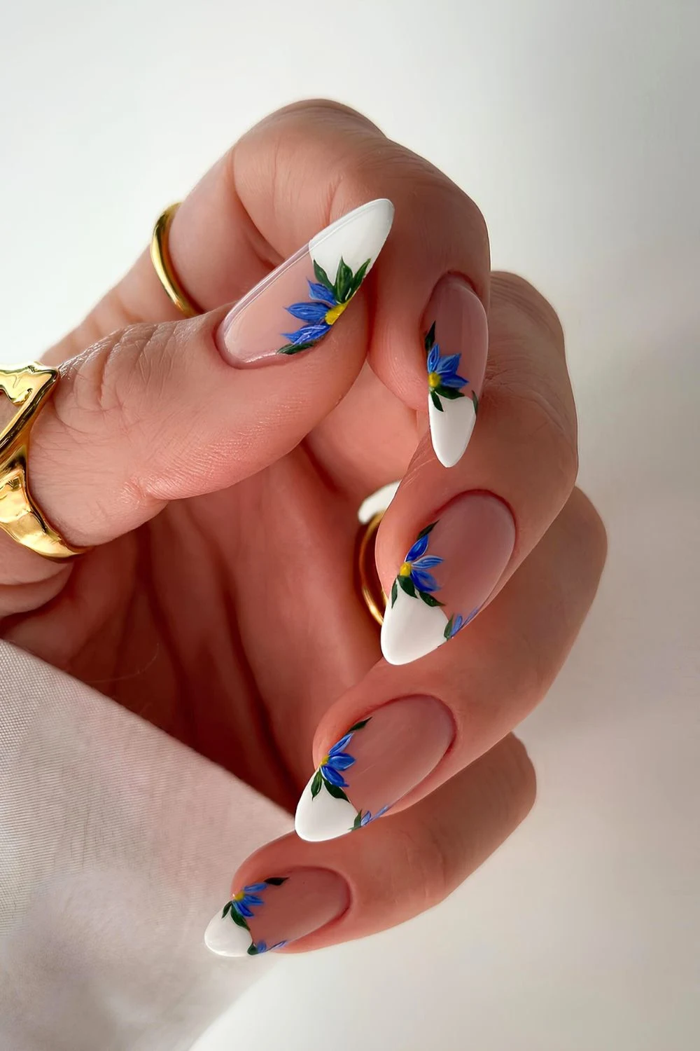 Weiße French-Nägel mit großen blauen Blumen