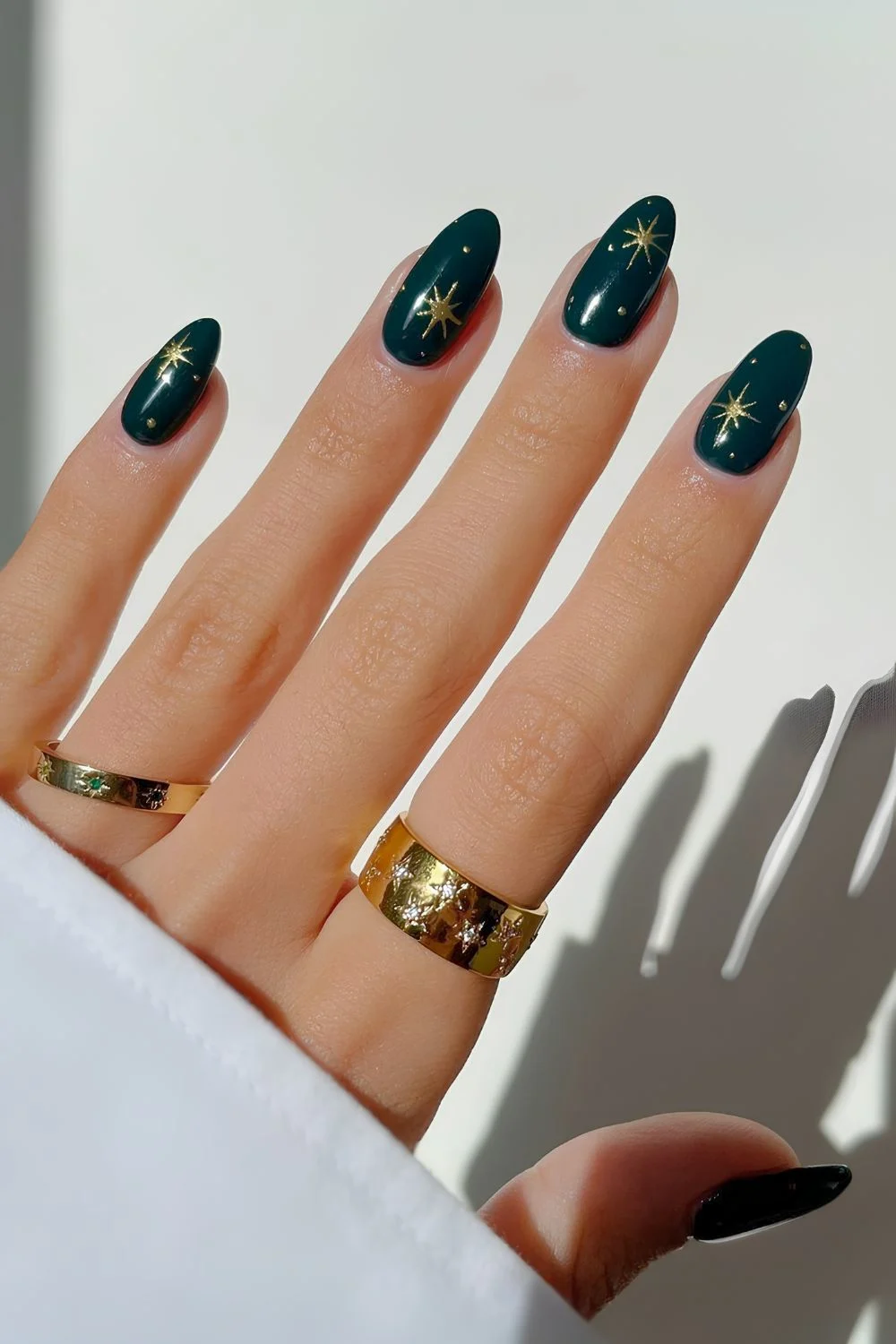 Dunkelgrüne Maniküre mit goldenen Chrome-Sternen