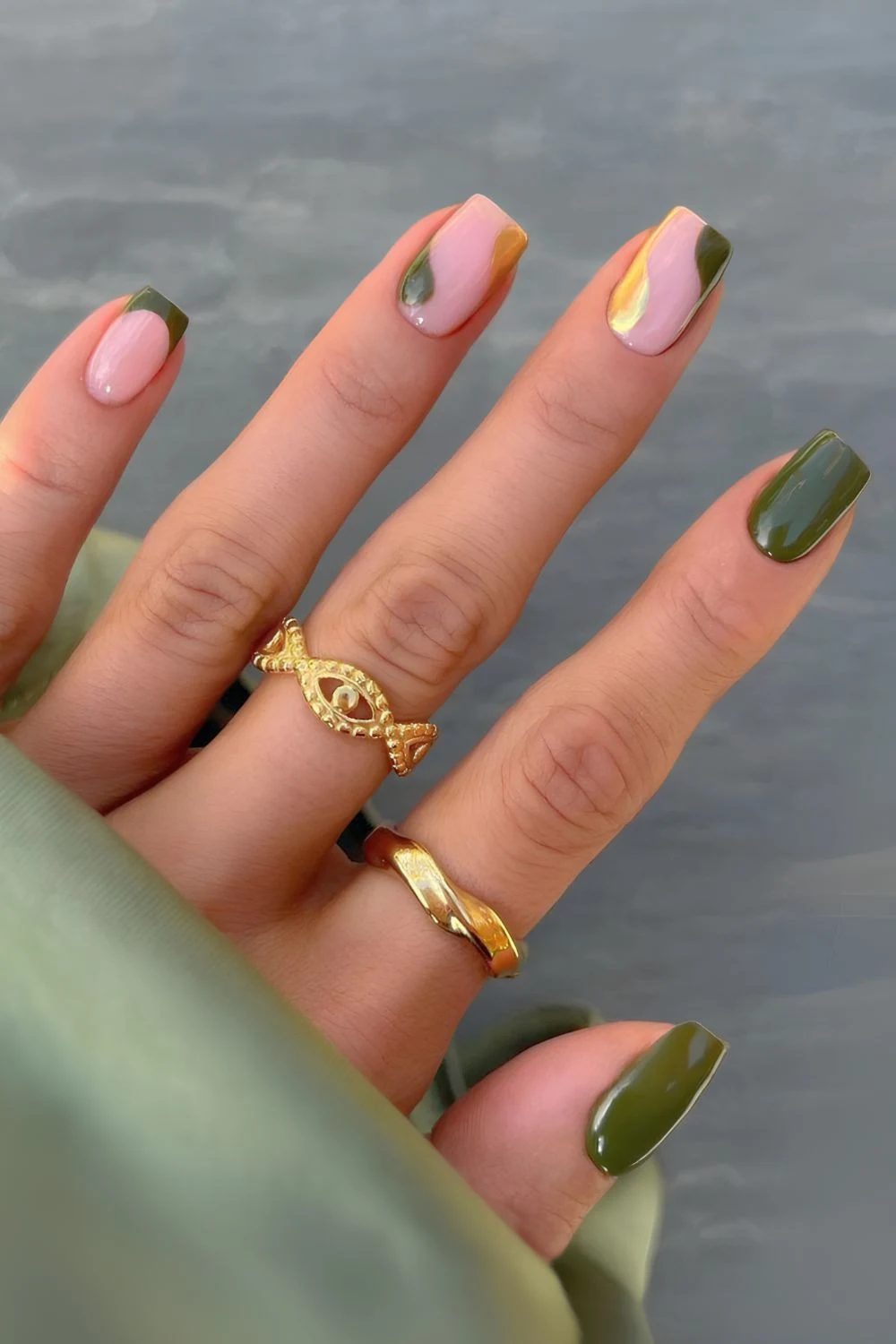 Goldene und grüne Nägel mit Negative-Space-Design