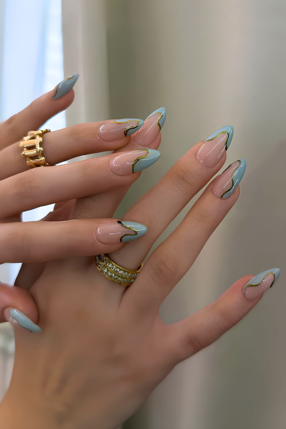 Abstrakte tealblaue French-Nägel mit Goldumrandung