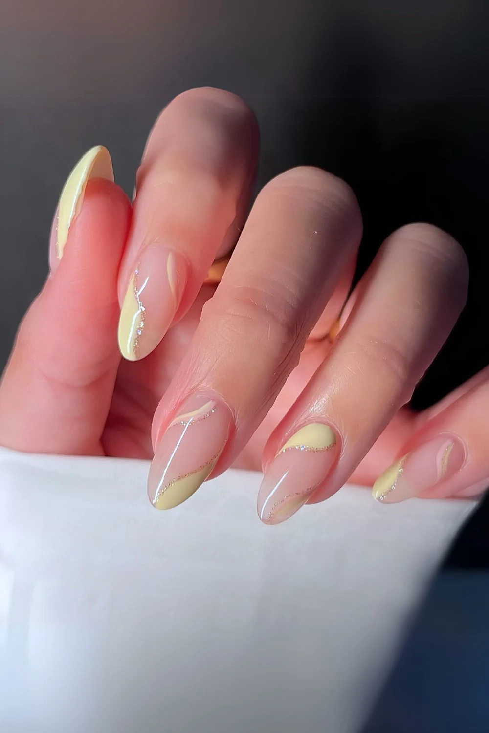 Buttergelbe Maniküre mit Swirls und Negative Space