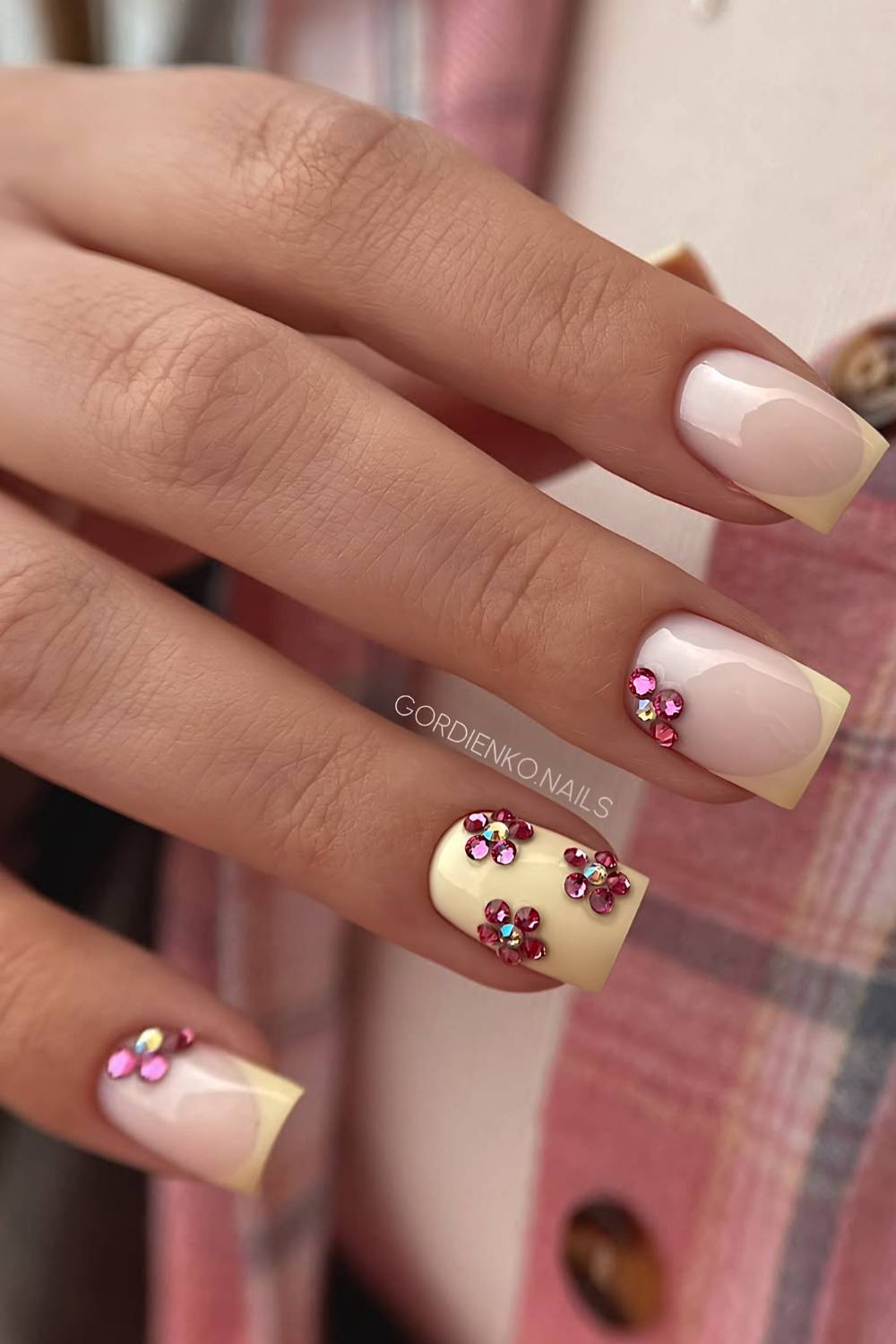 Buttergelbe Naegel mit pinken Strassblumen
