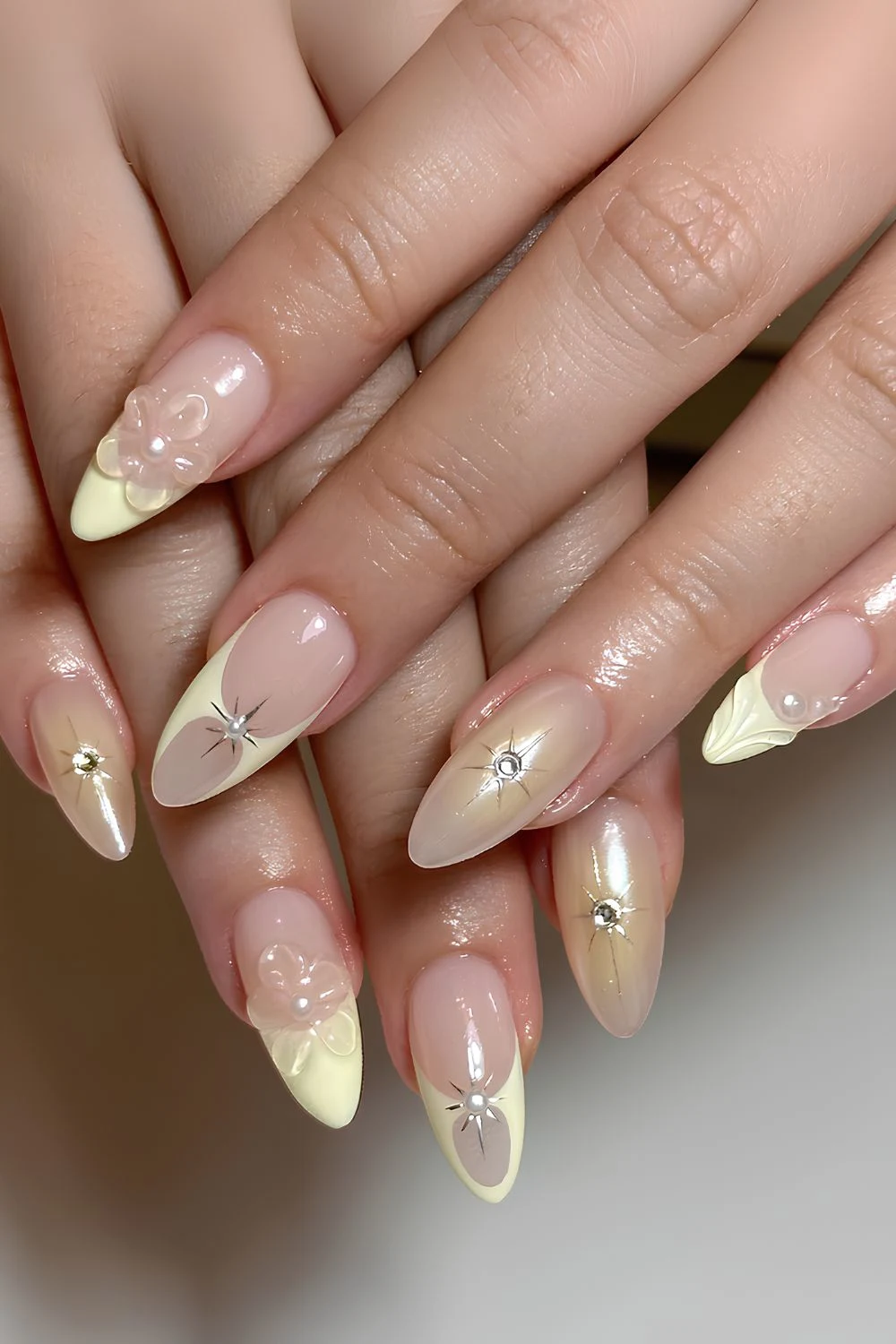 Gelbe Mix-and-Match-Nägel mit Blumen und Perlen