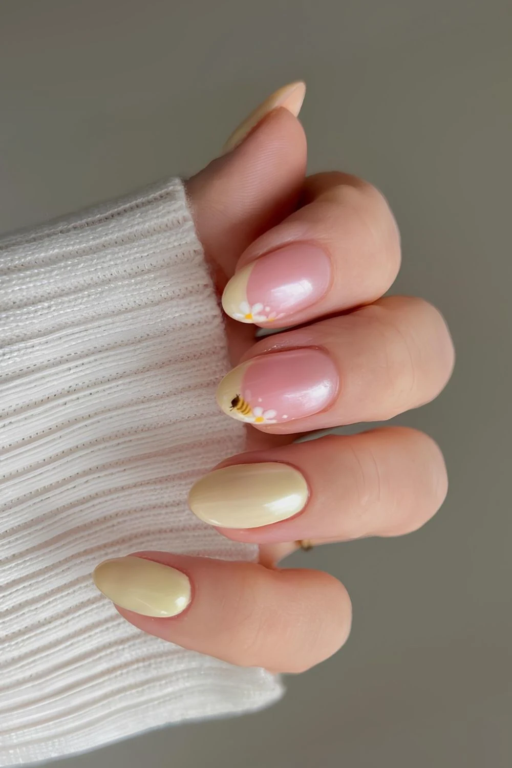 Glasierte gelbe Maniküre mit Bienen- und Gänseblümchen-Motiv