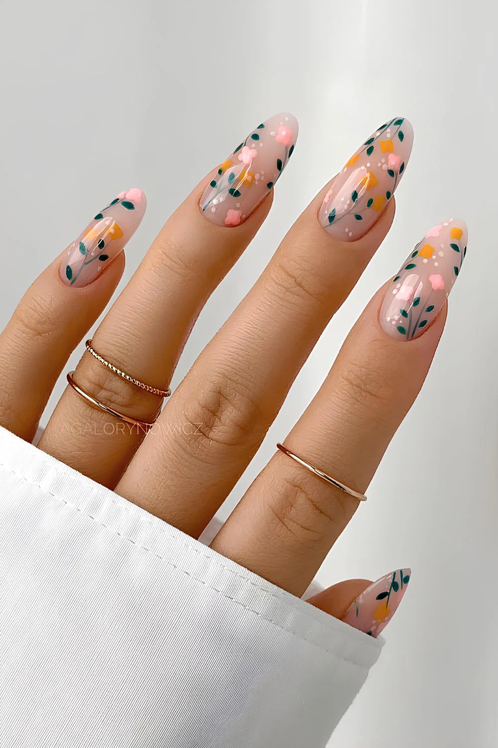 Milchige Mani mit Blumenakzenten in Orange, Pink und Grün