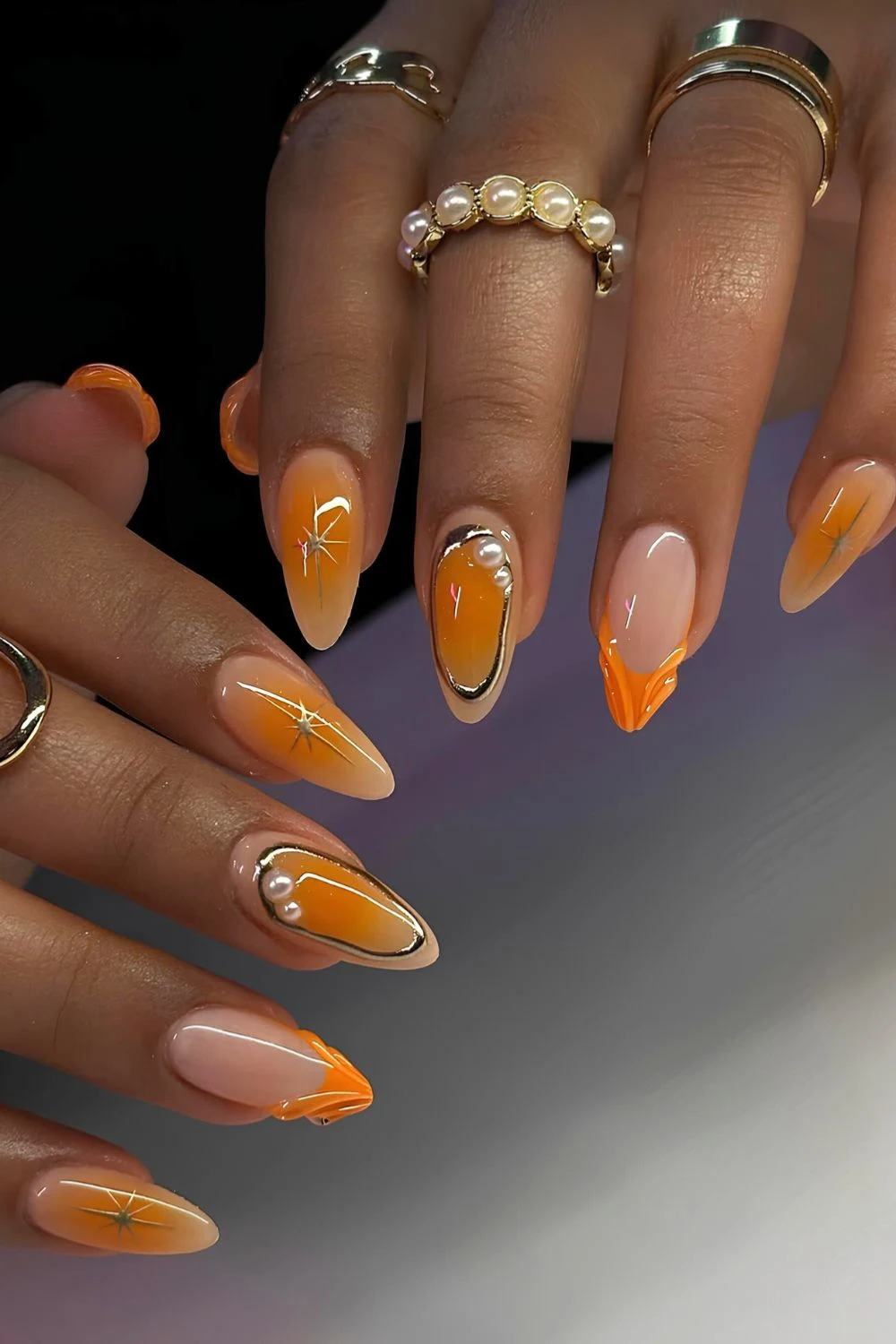 Orangefarbene Mani mit Mix-and-Match-Design