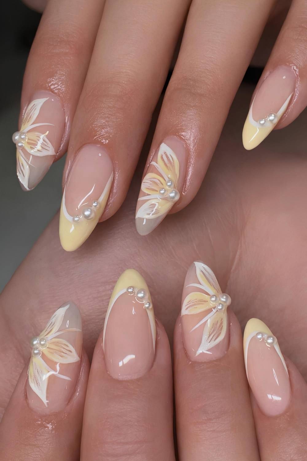 Pastellgelbe Naegel mit Blumen und Perlen