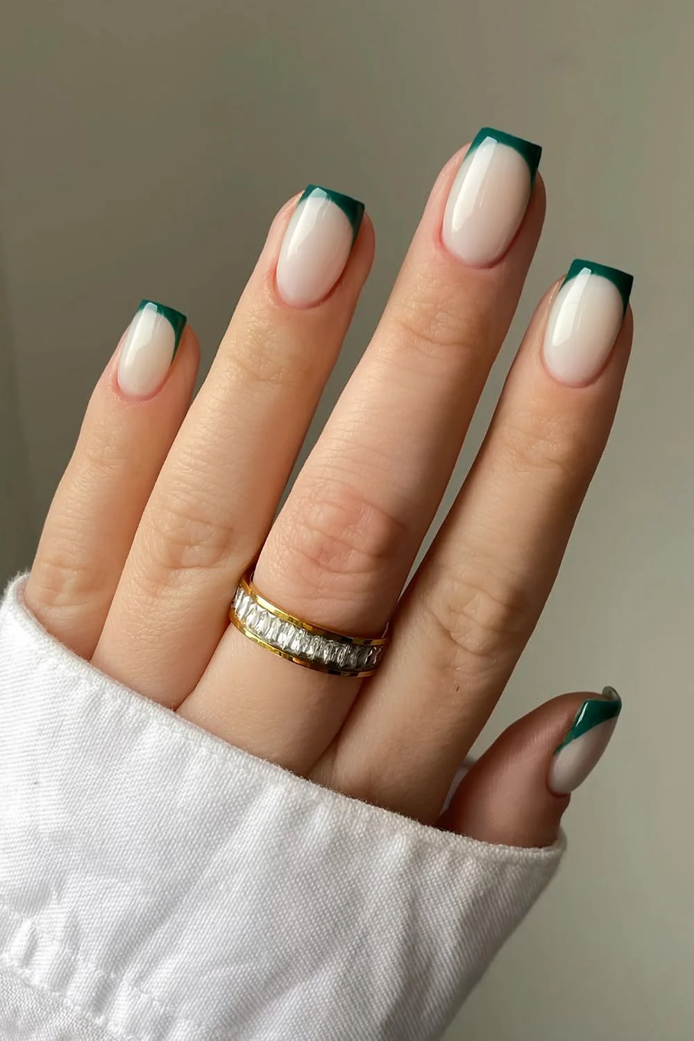 Smaragdgrüne French-Nägel auf milchigem Untergrund
