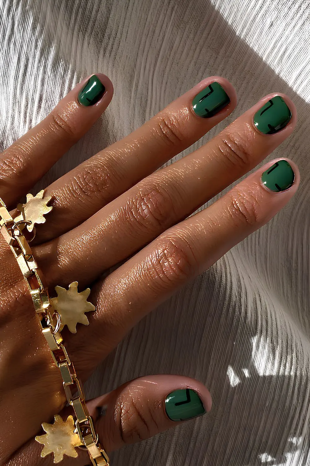 Smaragdgrüne Nägel mit geometrischer Kunst